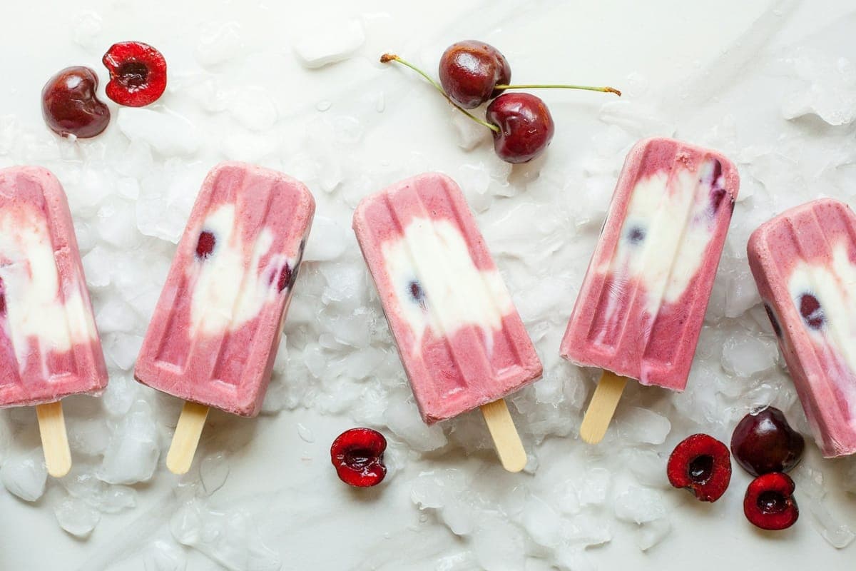 Cherry-vanilla custard pops on crushed ice with fresh cherries