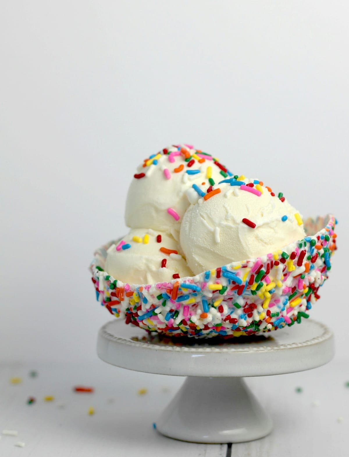 Vanilla custard scoops in a rainbow-sprinkle bowl